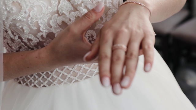 婚礼前新娘把结婚戒指戴在手指上。新娘轻触她的结婚金戒指视频下载