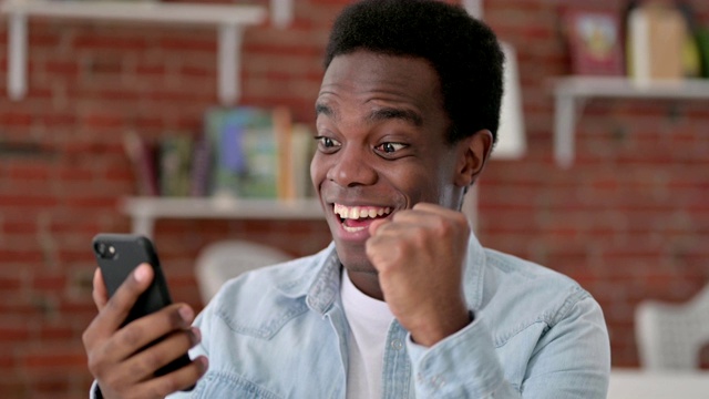 非洲男性在智能手机上庆祝视频素材