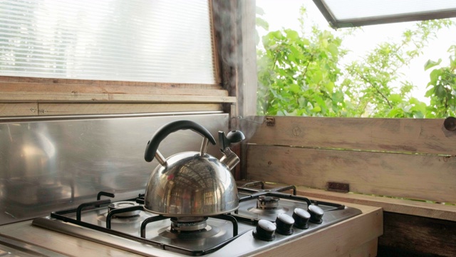 夏日乡村厨房里的水壶里冒出蒸汽。视频素材