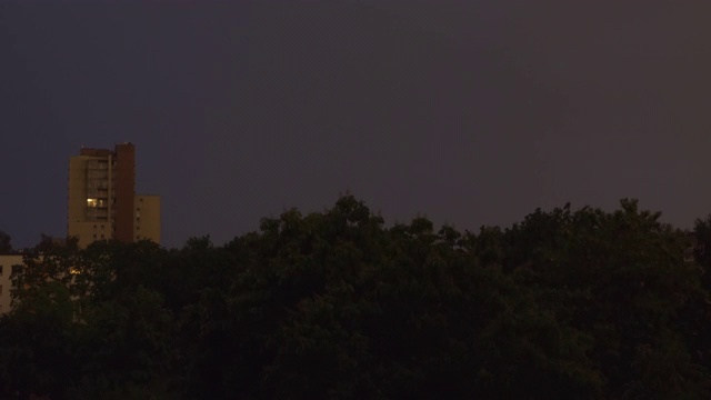 闪电击中了被树木包围的城市区域。雨夜的闪电。气候变化。视频素材