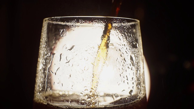 一股饮料流进一个漂亮的发光玻璃烧杯视频素材