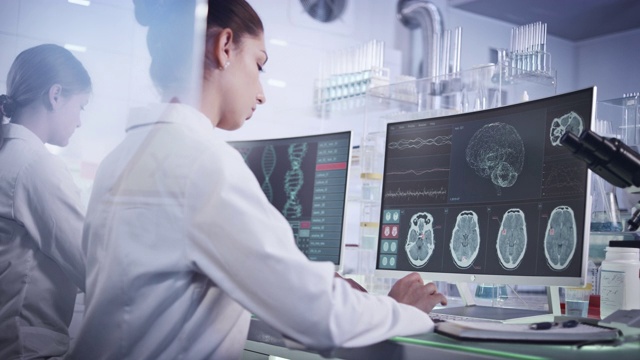 实验室女科学家。电脑屏幕上的脑电波扫描研究视频下载