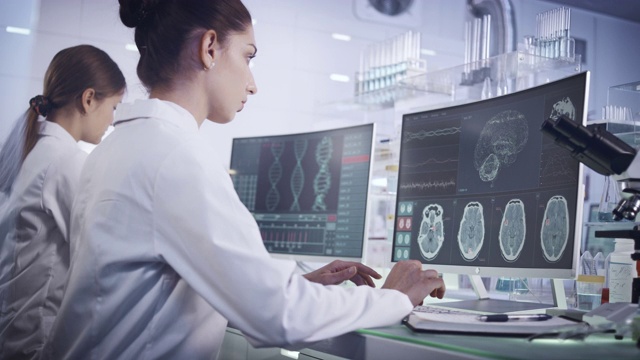 实验室女科学家。电脑屏幕上的脑电波扫描研究视频素材
