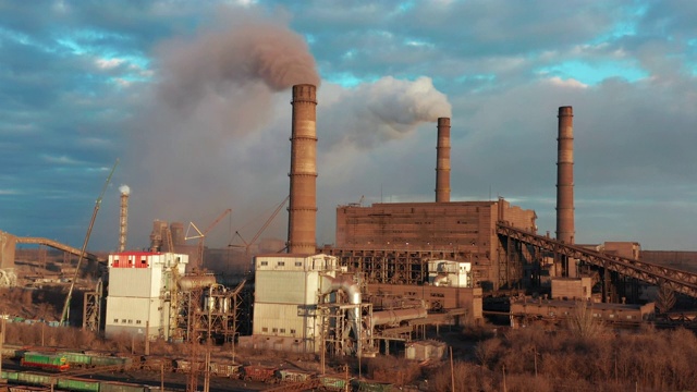 空气污染。从工厂的烟囱里冒出来的浓烟。一架无人机飞过一家钢铁厂冒着烟的烟囱视频素材