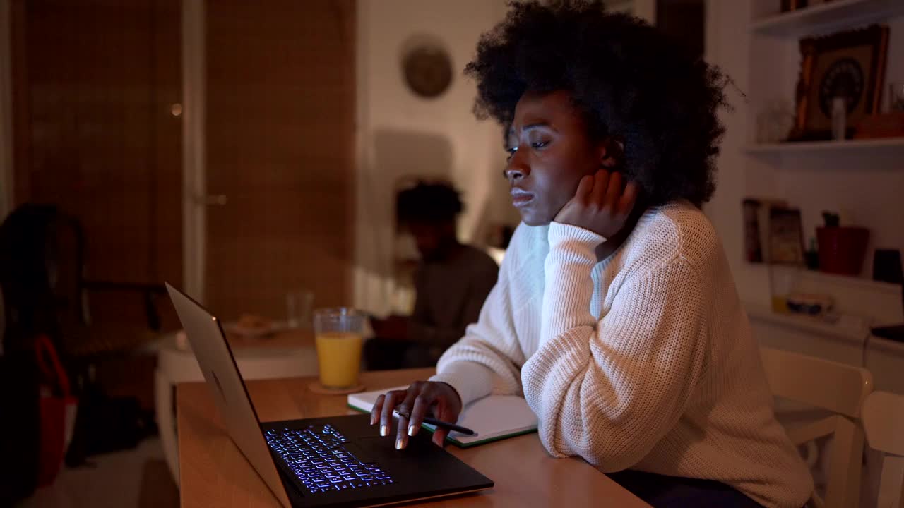 疲惫的年轻破产女子深夜用笔记本电脑上网找工作视频下载