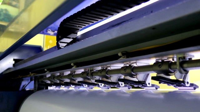 后面的大型喷墨打印机cmyk格式在车间工作视频素材
