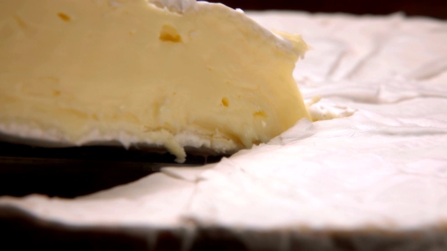 一个美味的软布里干酪的特写镜头从黑色的表面视频下载