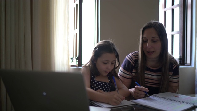 母亲在家里用笔记本电脑帮助女儿学习视频素材