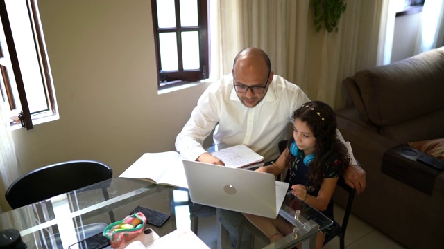 父亲帮助女儿做家庭作业视频聊天网上学习在家视频素材