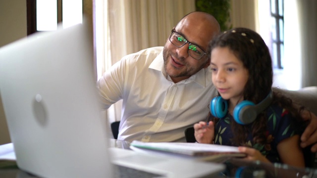 父亲帮助女儿做家庭作业视频聊天网上学习在家视频素材
