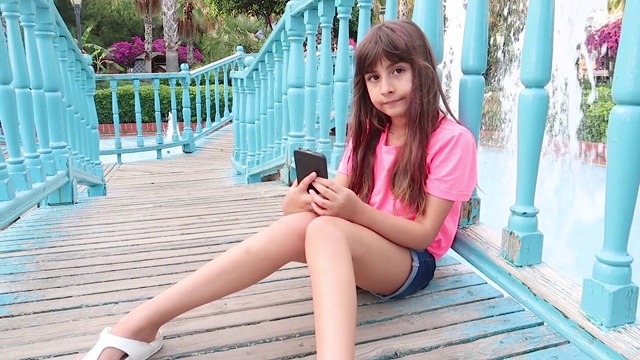 小女孩在公园玩手机视频下载