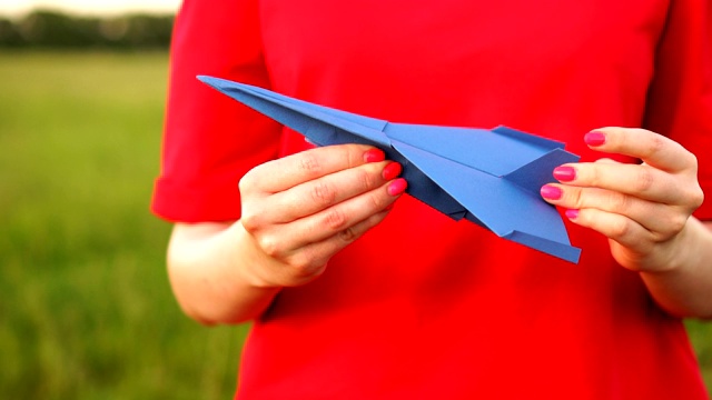 女性手握纸飞机。旅游，玩具，手工，童年，象征，旅游概念。视频素材