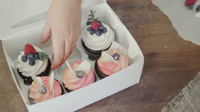 女人从盒子里拿自制的蛋糕。视频下载