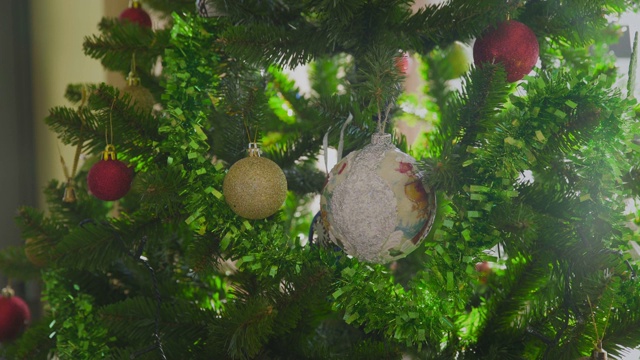 女人的手用彩球装饰圣诞树视频下载