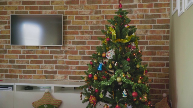 装饰灯的圣诞树。地板上有礼品盒和玩具蒸汽机。视频下载