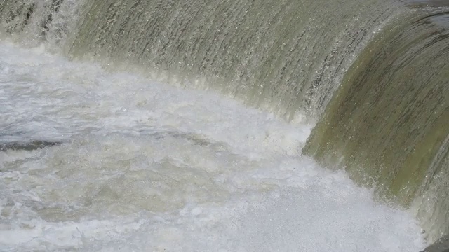 河水从屏障往下流。人们正在修建堤坝，通过控制河流的流速来减少风暴期间的侵蚀。暴雨后塞里奥河被淹视频素材