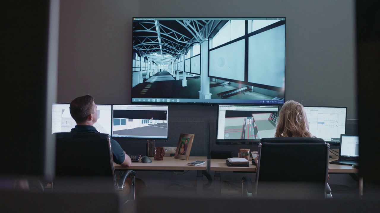 专注的设计专业人员在他们的电脑显示器上检查新建筑的3D模型蓝图视频素材