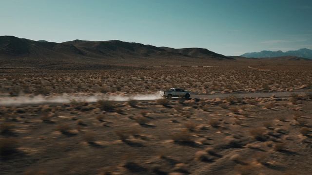 无人机拍摄的低角度跟踪拍摄，显示一辆卡车通过干燥的土路，内华达州，美国视频素材