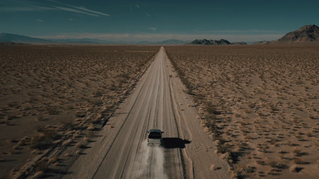 美国内华达州，一辆卡车在一条偏僻的干燥土路上行驶，后面跟着一架无人机拍摄视频下载