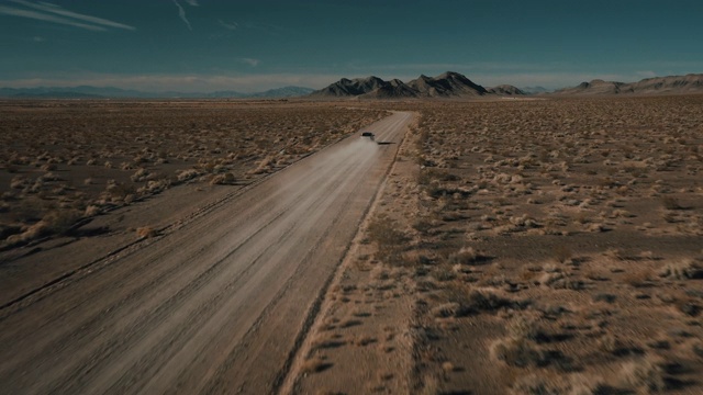 美国内华达州，一架无人机飞向一辆行驶在一条尘土飞扬的偏远公路上的卡车视频素材