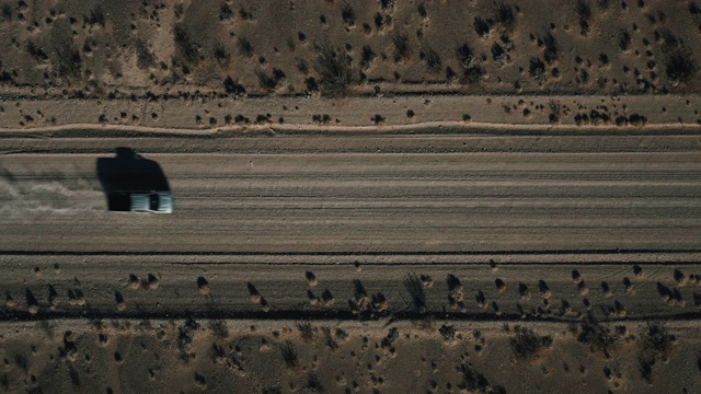 无人机拍摄盘旋在土路上方，一辆卡车通过框架，内华达州，美国视频素材