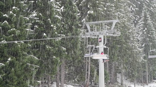 在暴风雪中滑雪缆车上的滑雪者。冬季山里的美丽假期。视频素材