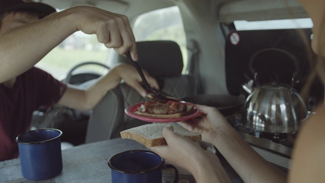 年轻的夫妇在露营车里做早餐和喝茶视频素材