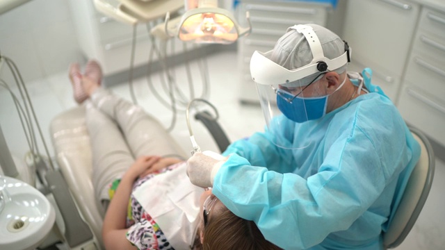 高级牙医正在检查一位年轻女子的牙齿视频下载