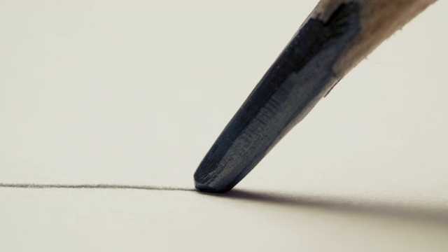 石墨铅笔在白色背景纸上画一条直线，微距拍摄视频素材