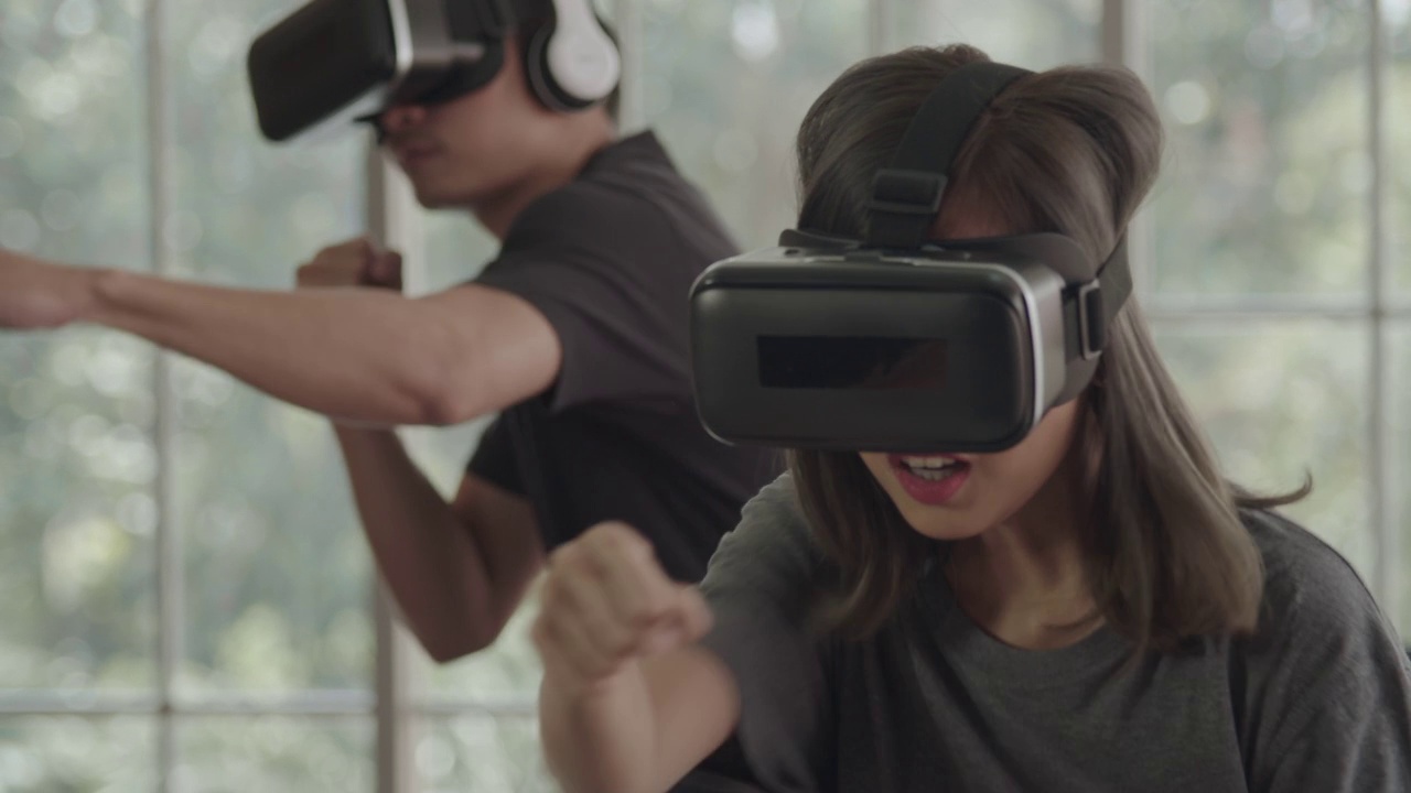亚洲年轻夫妇用虚拟现实护目镜在家里打拳击视频下载