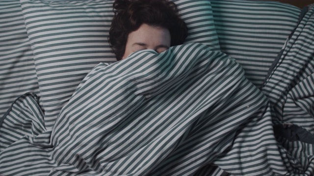 失眠的女人在盖毯子视频素材