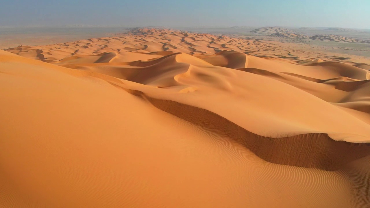 鲁卜哈利，又名阿拉伯半岛的空区沙漠。在炎热的夏天，在弯曲的沙丘上飞翔。空中射击,4 k视频下载