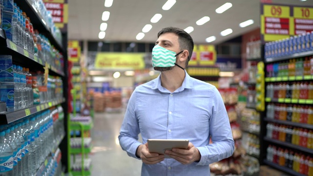 超市员工或老板戴口罩行走和使用数码平板电脑视频素材