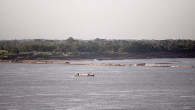 当地渡船经过湄公河上的长竹桥视频素材