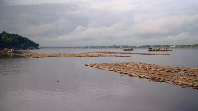 渡船在河上互相往来;前景是水面上的竹制地板视频素材