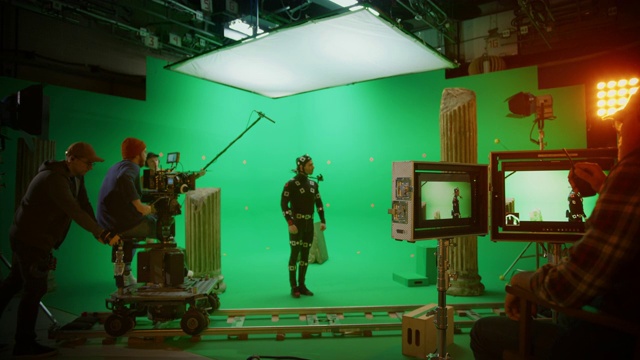 在大电影制片厂专业摄制组拍摄大片。导演命令摄影师开始拍摄绿色屏幕CGI场景与演员穿着动作捕捉服和头部钻机视频素材