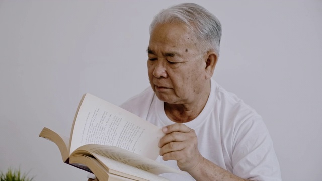 老人在读一本书。视频素材