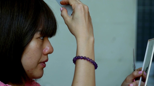 剪短头发的亚洲妇女自己在家理发视频下载