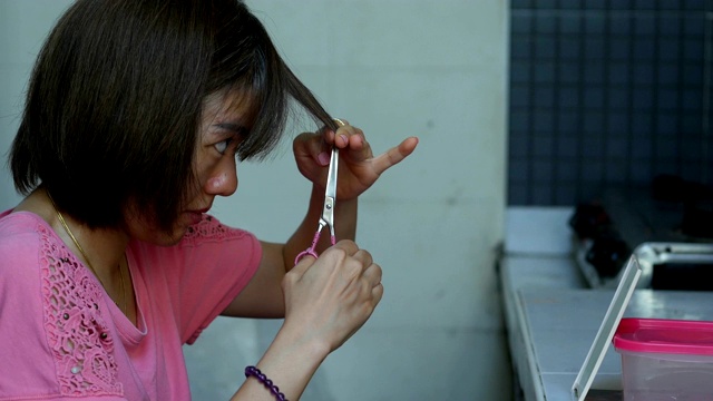 剪短头发的亚洲妇女自己在家理发视频下载