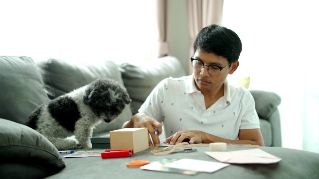 年轻的亚洲人写一个礼物盒和一张快乐的笑脸卡片视频下载