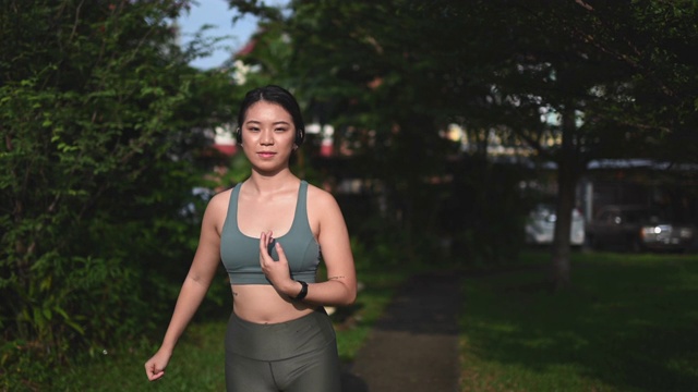 一位亚裔华裔少女穿着运动服在公园晨跑视频素材