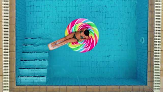 俯视图的女人与游泳池浮在游泳池视频下载