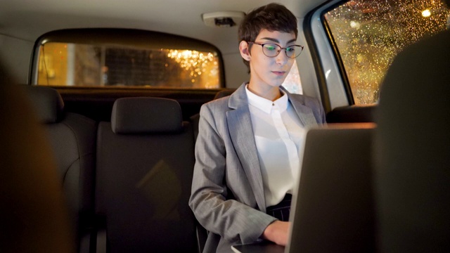 年轻的女企业家晚上在车里用笔记本电脑工作视频素材