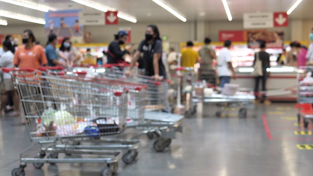模糊背景组的人购买新鲜的食品从超市货架视频下载