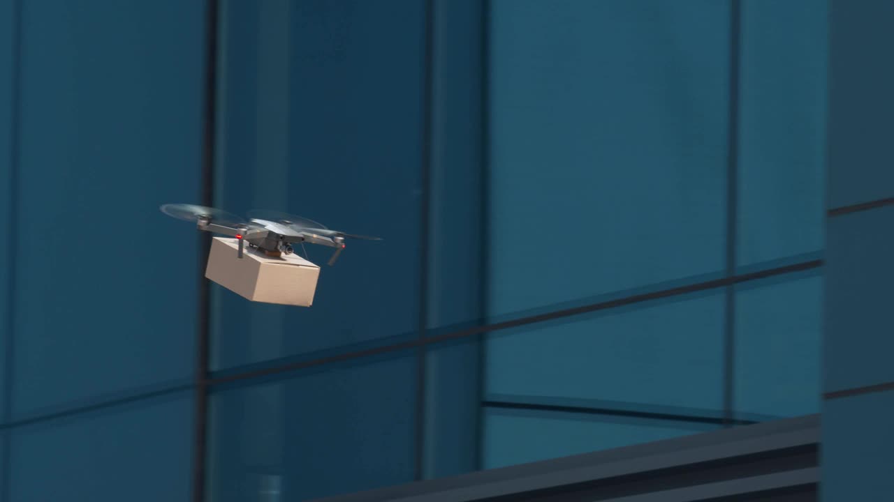 无人机带着包裹在市区快速飞行视频素材