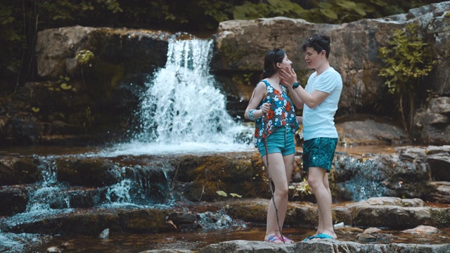 年轻夫妇探索瀑布和享受森林徒步旅行。旅行的概念。视频素材