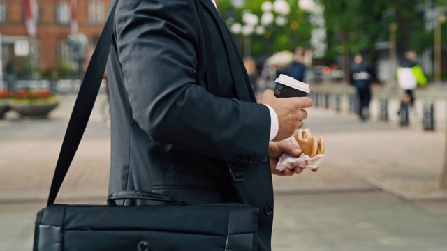 生意人在上班的路上吃着汉堡喝着咖啡视频素材