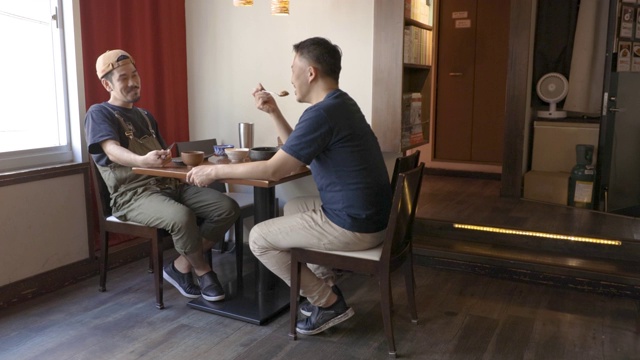 两名男子在居酒屋(日本酒吧)吃午餐时交谈视频素材