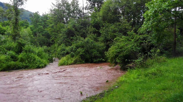 湍急的河水流过村庄，把前面的一切都冲走了——浑浊湍急的河水——暴雨——自然灾害视频素材