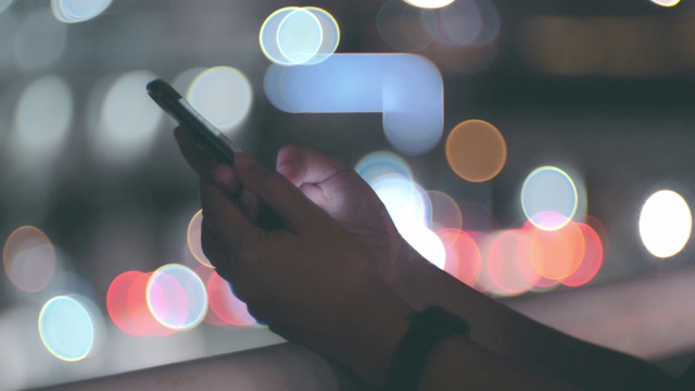 Cu:晚上在城市里使用智能手机的女人视频素材
